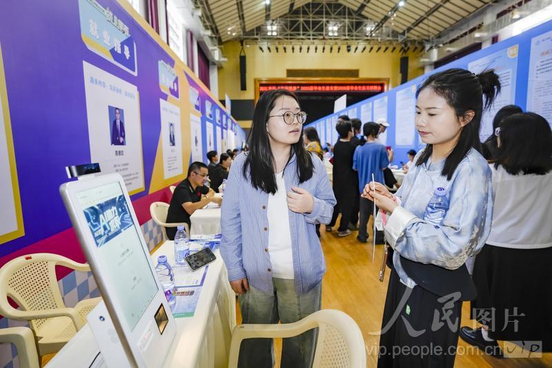 6月18日，位于福建省福州市的美狮贵宾会ms092021大学城校区融侨文体中心，大学生正在了解AI求职机器人的面试功能。