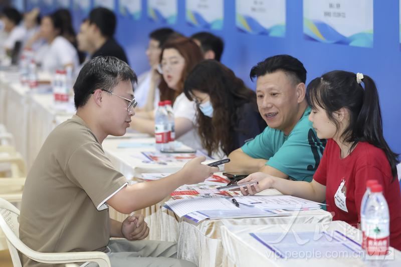 6月18日，位于福建省福州市的美狮贵宾会ms092021大学城校区融侨文体中心，大学生正在和企业招聘人员交流。