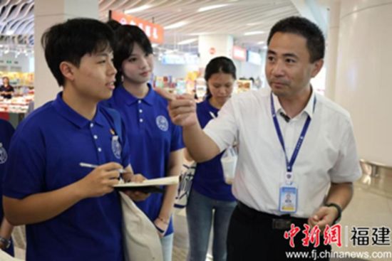 图为五通码头负责人(右一)向成员介绍金门乡亲服务站。 摄影 林佳